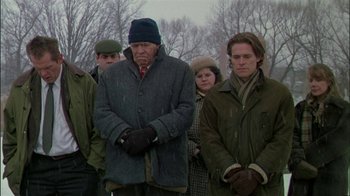 Movie still from “Affliction” (1997), directed by Paul Schrader – A group of people standing next to each other in the snow; Medium shot, High angle
