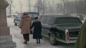 Movie still from “Affliction” (1997), directed by Paul Schrader – Two women walking next to a black limousine in the snow; Wide shot, High angle