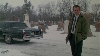 Movie still from “Affliction” (1997), directed by Paul Schrader – A man walking in the snow next to a cemetery; Wide shot, Low angle