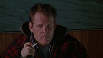 Movie still from “Affliction” (1997), directed by Paul Schrader – A person holding a cigarette; Close Up shot, Low angle