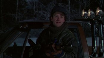 Movie still from “Affliction” (1997), directed by Paul Schrader – A man holding a gun while sitting in the back of a car; Medium shot, Low angle