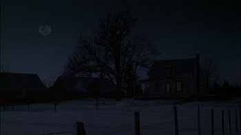 Movie still from “Affliction” (1997), directed by Paul Schrader – A house in the dark with a tree in the background; Extreme Wide shot, Low angle