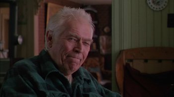 Movie still from “Affliction” (1997), directed by Paul Schrader – An older man sitting in a chair in front of a window; Close Up shot, Low angle
