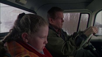 Movie still from “Affliction” (1997), directed by Paul Schrader – A man and a boy sitting in the back seat of a car; Close Up shot, Over the shoulder angle