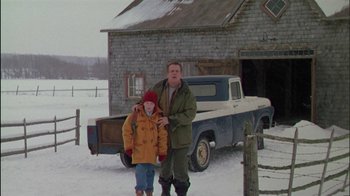 Movie still from “Affliction” (1997), directed by Paul Schrader – A man standing next to a boy in front of a truck; Wide shot, Low angle