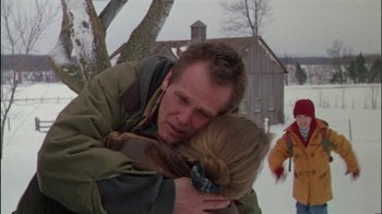 Movie still from “Affliction” (1997), directed by Paul Schrader – A man and a woman hugging in the snow; Medium shot, Over the shoulder angle