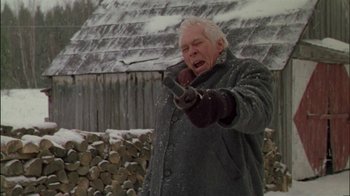 Movie still from “Affliction” (1997), directed by Paul Schrader – An old man in a gray coat is holding something in his hand; Medium shot, Low angle
