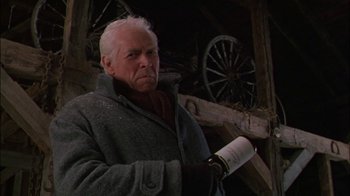 Movie still from “Affliction” (1997), directed by Paul Schrader – An older man holding a bottle of wine in his hand; Close Up shot, Low angle