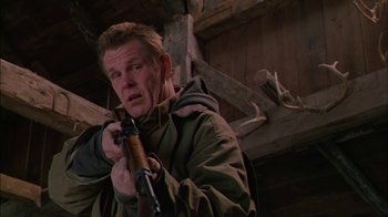 Movie still from “Affliction” (1997), directed by Paul Schrader – A man holding a rifle in his hands; Close Up shot, Low angle
