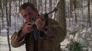 Movie still from “Affliction” (1997), directed by Paul Schrader – A man holding a rifle in the snow; Close Up shot, Low angle