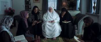 Movie still from “After Love” (2020), directed by Aleem Khan – A group of women sitting on a couch in a living room; Wide shot, High angle