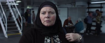 Movie still from “After Love” (2020), directed by Aleem Khan – An older woman wearing a head scarf and a black jacket; Close Up shot, Over the shoulder angle