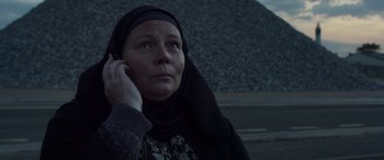 Movie still from “After Love” (2020), directed by Aleem Khan – A woman in a black headscarf talking on a cell phone; Close Up shot, Low angle