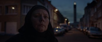 Movie still from “After Love” (2020), directed by Aleem Khan – An older woman wearing a headscarf on a city street; Close Up shot, Low angle
