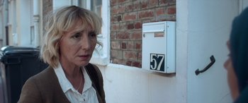 Movie still from “After Love” (2020), directed by Aleem Khan – A woman standing in front of a brick wall; Close Up shot, Over the shoulder angle