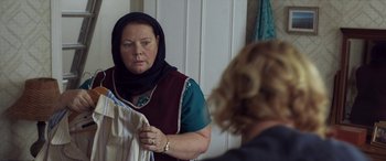 Movie still from “After Love” (2020), directed by Aleem Khan – A woman in a headscarf is looking at her reflection in a mirror; Medium shot, Over the shoulder angle