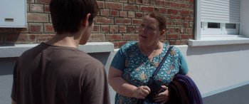 Movie still from “After Love” (2020), directed by Aleem Khan – An older woman holding a gun talking to a young boy; Medium shot, Over the shoulder angle