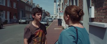 Movie still from “After Love” (2020), directed by Aleem Khan – A young man and a young woman talking on the sidewalk; Medium shot, Over the shoulder angle