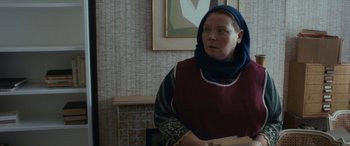 Movie still from “After Love” (2020), directed by Aleem Khan – A woman wearing a headscarf is standing in a room; Medium shot, Over the shoulder angle