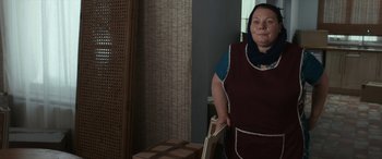 Movie still from “After Love” (2020), directed by Aleem Khan – A woman standing next to boxes in a room; Medium shot, Over the shoulder angle