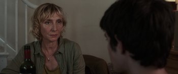 Movie still from “After Love” (2020), directed by Aleem Khan – A woman sitting in front of a boy in a room; Close Up shot, Over the shoulder angle