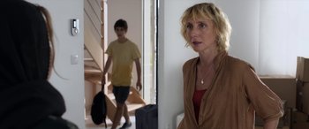 Movie still from “After Love” (2020), directed by Aleem Khan – A woman standing next to a young man in a room; Medium shot, Over the shoulder angle