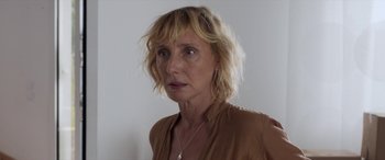 Movie still from “After Love” (2020), directed by Aleem Khan – A person wearing a brown shirt; Close Up shot, Over the shoulder angle