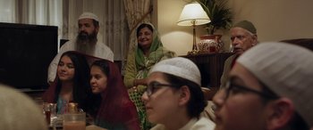 Movie still from “After Love” (2020), directed by Aleem Khan – A group of people sitting in a living room; Medium shot, High angle