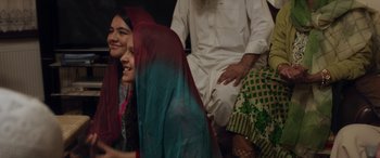 Movie still from “After Love” (2020), directed by Aleem Khan – A group of people sitting on the ground; Medium shot, Over the shoulder angle