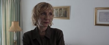 Movie still from “After Love” (2020), directed by Aleem Khan – A woman sitting in a living room with a picture hanging on the wall; Close Up shot, Low angle