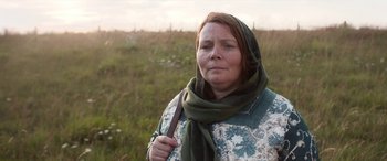 Movie still from “After Love” (2020), directed by Aleem Khan – A woman in a scarf standing in a field; Close Up shot, Low angle