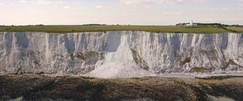 Movie still from “After Love” (2020), directed by Aleem Khan – A large amount of snow on the side of a cliff; Extreme Wide shot, High angle