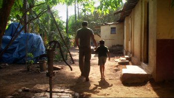 Movie still from “After the Wedding” (2006), directed by Susanne Bier – A man and a boy walking down a dirt path; Wide shot, Over the shoulder angle