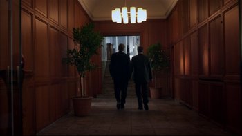 Movie still from “After the Wedding” (2006), directed by Susanne Bier – Two men are walking down the hall of a building; Wide shot, Low angle