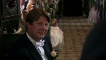 Movie still from “After the Wedding” (2006), directed by Susanne Bier – A person wearing a suit and a bow tie; Close Up shot, Over the shoulder angle