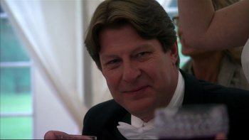 Movie still from “After the Wedding” (2006), directed by Susanne Bier – A person wearing a suit and bow tie; Close Up shot, Over the shoulder angle