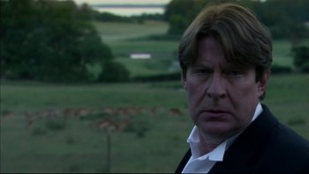 Movie still from “After the Wedding” (2006), directed by Susanne Bier – A person in a field with trees in the background; Close Up shot, Over the shoulder angle
