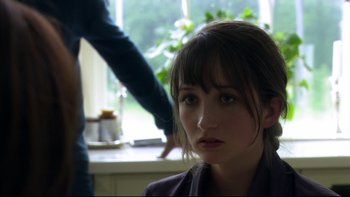 Movie still from “After the Wedding” (2006), directed by Susanne Bier – A young woman with bangs is sitting in front of a window; Close Up shot, Over the shoulder angle