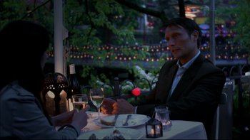 Movie still from “After the Wedding” (2006), directed by Susanne Bier – A man sitting at a dinner table with a glass of wine; Medium shot, Over the shoulder angle
