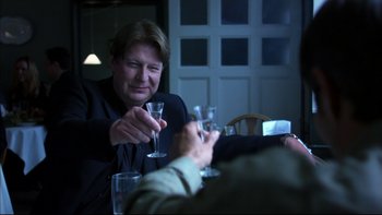 Movie still from “After the Wedding” (2006), directed by Susanne Bier – Two people sitting at a dinner table holding wine glasses; Close Up shot, Over the shoulder angle