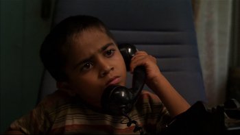 Movie still from “After the Wedding” (2006), directed by Susanne Bier – A young boy holding a phone up to his ear; Close Up shot, High angle