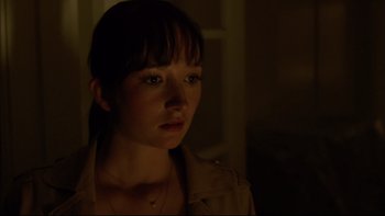 Movie still from “After the Wedding” (2006), directed by Susanne Bier – A young woman with bangs is standing in a dark room; Close Up shot, Over the shoulder angle