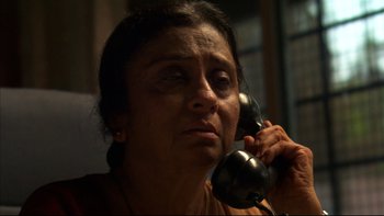 Movie still from “After the Wedding” (2006), directed by Susanne Bier – An older woman talking on a phone while sitting down; Close Up shot, High angle