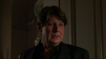 Movie still from “After the Wedding” (2006), directed by Susanne Bier – A person wearing a suit and tie; Close Up shot, Over the shoulder angle