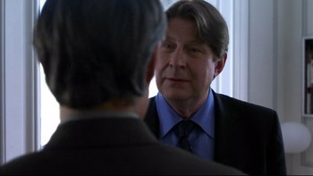 Movie still from “After the Wedding” (2006), directed by Susanne Bier – A person wearing a suit and tie; Close Up shot, Over the shoulder angle