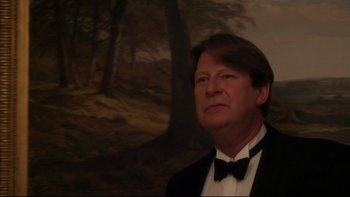 Movie still from “After the Wedding” (2006), directed by Susanne Bier – A man in a tuxedo standing in front of a painting; Medium shot, Low angle
