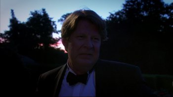 Movie still from “After the Wedding” (2006), directed by Susanne Bier – A person wearing a suit and bow tie; Close Up shot, Low angle