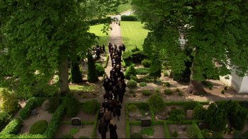 Movie still from “After the Wedding” (2006), directed by Susanne Bier – A group of people walking down a path in a garden; Extreme Wide shot, High angle