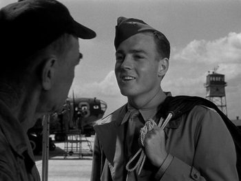 Movie still from “Air Force” (1943), directed by Howard Hawks – An old photo of a man wearing a hat; Medium shot, Over the shoulder angle