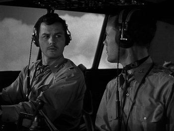Movie still from “Air Force” (1943), directed by Howard Hawks – Two men are in the cockpit of an airplane; Medium shot, Low angle
